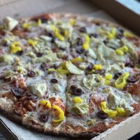 Gluten-free and vegan cauliflower crust with vegan cheese, banana peppers, artichokes, and olives   at Mooses Tooth in Anchorage