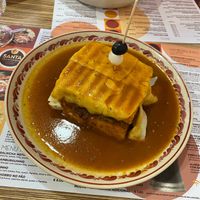 Francesinha 100% vegan (pão de forma, cogumelos, tomate, cebola, bifinhos de seitan, queijo vegetal, chouriço de soja, courgette, salsicha vegana e molho 100% vegano) - 13,90€ at Santa Francesinha in Porto