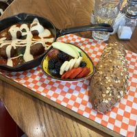 Plant-based (vegan) shakshuka with side of fruit and multigrain bread.   at Cafe Landwer - University Ave in Toronto