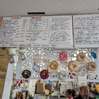 Donut display inside of Old Abe's Coffee with the day's flavors at Drift Dough in Rochester