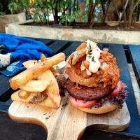 Burger from black beans, walnut with fried onion rings at Coco Calala in Leon