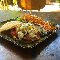 Burger with soy patty, rice paper bacon and ranch dressing, side salad at Coco Calala in Leon