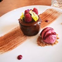 A chocolate cake with red fruit ice cream, beautifully presented! at Kong - Food Made With Compassion in Lisbon