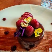A chocolate cake with red fruit ice cream, beautifully presented! at Kong - Food Made With Compassion in Lisbon