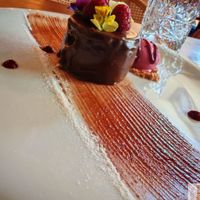 A chocolate cake with red fruit ice cream, beautifully presented! at Kong - Food Made With Compassion in Lisbon