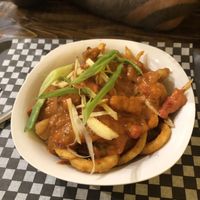 Butter chicken poutine on curly fries! at The Pizza Castle and Indian Curry in Vancouver