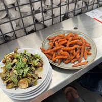 À la  carte sweet potato fries and the fried/glazed Brussels sprouts. Beyond burgers also available to sub on their burgers. Beer not pictured  at Bird Creek Burger Co in Temple