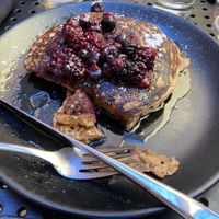 Vegan pancakes with berries, powdered sugar, and syrup. at The Hummingbird Cafe in Butte