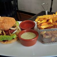 Hamburguesa con patatas y salsas at The Hen's Teeth in Alicante