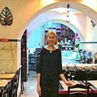 The very nice hostess at the wonderful Jardim das Cerejas with a 
bountiful buffet and diplomatic vegan chocolate salami in the background. at Jardim das Cerejas - Chiado in Lisbon