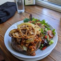 Jacket potato with beans and vegan haggis, topped with crispy onions at Pixie Bakes Cakery and Coffee Shop in Tintwistle
