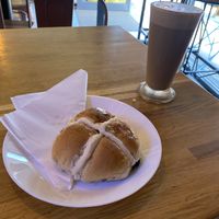 Hot cross bun and latte to sit in  at Dough Artisan Bakehouse in South East London