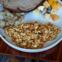 Scrambled tofu with potatoes and toast served with fruit at Pumpkin Tales in Chennai