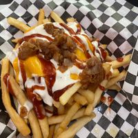 BBQ ranch fries (fries topped with grilled onions, ranch, BBQ sauce, and cheese) at Plant Slayer in Fresno