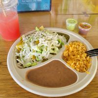 Aqua fresca watermelon with El pastor enchiladas covered in salsa Verde sauce with refried beans and rice. at Veegos in Houston