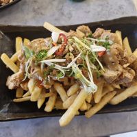 Vegan Chickaan Peanut Butter Fries: Plantbased crispy chickaan, crispy shallots, spring onions, fresh chillies, crushed pistachios, homemade peanut butter & sriracha sauce at Viet Shack in Manchester