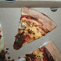 One bite of toppings on a slice. at Crust Gourmet Pizza Bar in Richmond