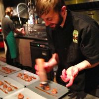 Chef Patterson decorates the plated Rose-Chocolate-Coconut Mousse. at Sutra in Seattle