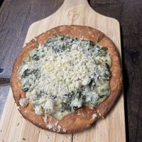 The Space Swamp! The dough was sweeter than expected, and the topping wasn’t quite like parmesan, though the spinach and saucy cheese were still nice.  at Pythagoras Conscious Food Philosophy in Houston