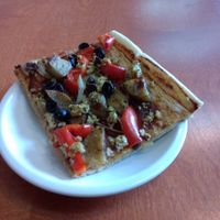 Pizza slice with potatoes and scrambled tofu. at Alpine Bakery in Whitehorse