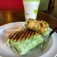 Vegan Treehugger Wrap- Tofu scramble, tots, spinach, sautéed peppers and onions, vegan breakfast sausage, vegan cheese, and tomatoes at Drunken Monkey Coffee Bar in Orlando