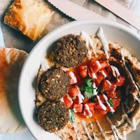 Hummus bowl with tomatoes and falafel. Baklava on the side.  at Simply Hummus Bar in Darlinghurst