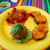 Stuffed roast tomatoes with tarwi pesto and pecans,  sweet potatoes in mandarin honey and sautéed sweet onion and green papaya.  at Pachamama Health in Veracruz