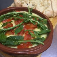 Provolone cheese with tomato and arugula, served with sourdough bread at Liberty Bar in Montevideo