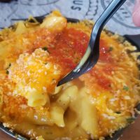 Vegan mac and cheese, showing off the gooey goodness (with hot sauce on top) at World Famous House of Mac in Miami
