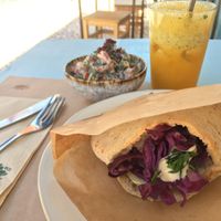 Falafel pitta in the front, "Middle Eastern" salad and orange juice in the back at Yallah in Lisbon