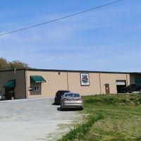 Building, parking lot, entrance and drive thru window. at Pisgah Coffee Roasters in Pisgah Forest
