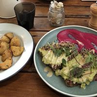 Smashed avocado with macadamia cheese, hemp seed dukkah, beetroot hummus on gluten-free seedy brown bread and roasted potatoes with vegan mayo at Girdlers in Brookvale