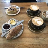 Cappuccino, latte, cinnamon roll, and croissant at Chapter One Coffee Shop in Edinburgh