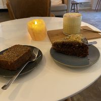 Banana bread (quite nice), carrot cake (very good and moist) and golden latte (very good) with a small piece of tahini square (quite nice)  at Plenty in The Hague