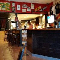 View near the restaurant entrance of order counter, kitchen, and back venue entrance. at Mark of the Beastro in Salt Lake City