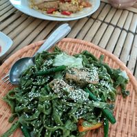 Spinach noodles in pesto sauce (vegan) with smokey tempeh and tofu tortilla in the background at Mama's Garden - Maybe closed in 
