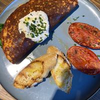 Chickpea omelette with grilled tomato and buckwheat bread at Eqvilibrivm Cafe in Barcelona
