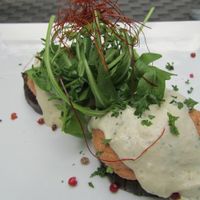 baked eggplant rounds topped with tofu Bolognese, cashew crème, on bed of greens at La Mano Verde in Berlin
