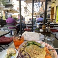Vegan salad with added smoked tofu, bread and olive on the side and an aperol spritz  at Bruscè in Bologna
