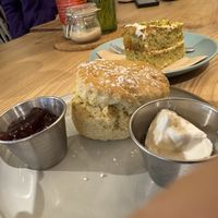 Vegan cream tea with vegan pistachio cake in the background   at The Courtyard in Looe