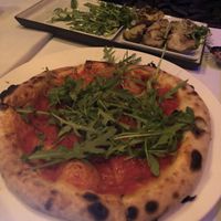 Tomoro pizza with rocket and artichoke salad plate at La Gioia in Paris