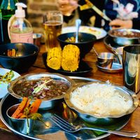 Chloe Chawal plate (vegan + GF) next to sides inc grilled corn on the cob, okra chips and Bhel   at Dishoom - King's Cross in London