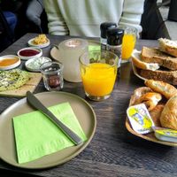 Charlie's breakfast veganized on demand: sliced bread, hummus, creamy tofu spread with fresh herbs, pear-vanilla jam, raspberry jam, homemade chocolate spread, freshly pressed oran at Charlie's in Antwerpen