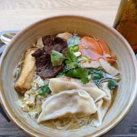 Joyful Taiwan noodle soup with rice noodles, dumplings, Chinese cabbage, edamame, shiitake chunks, soy meat, tofu, scallion & cilantro at Liu Lin in Brussels