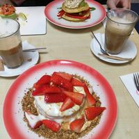 vegan pancakes with strawberries, yoghurt and granola plus in the back vegan savory pancakes with hummus, grilled pepper and avocado at Moak Pancakes - West in Amsterdam