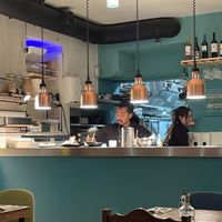 Staff putting beautiful finishing touches on dishes.   at O Gambuzino in Lisbon