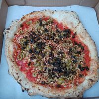 Nuda non nuda: olives vertes, câpres frites et morceaux de cajous at Nina Pizza in Quebec