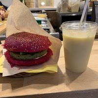 Burger con pane alla rapa rossa, burger di quinoa e verdure, verdure cotte e maionese vegana. Smoothie Sunset.  at Nectare in Bologna