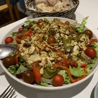 Hearty, delicious green salad with cherry tomatoes, grilled aubergine and paprika, roasted almond splitter and pesto.   at Curcuma in Vigo