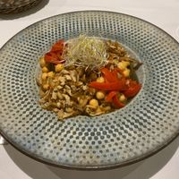Tender chickpeas with a little bite with smoked tofu, aubergine, paprika and alfa alfa on top    at Curcuma in Vigo